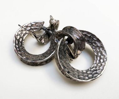 Beyaz arkaplanda bir çift gümüş kol düğmesi yakın plan