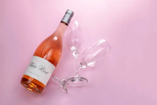 stock image Wine bottle and two glasses on pink background. Top view.