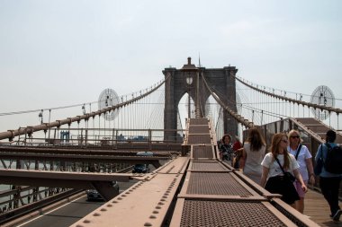 İnsanlar New York 'taki Brooklyn Köprüsü' nü ziyaret ediyor. Köprü, Manhattan ve Brooklyn arasındaki Doğu Nehri boyunca uzanır..