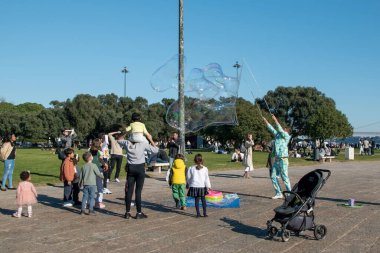 Çocuklar ve yetişkinler parkta eğleniyor..