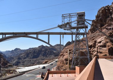 Hoover Barajı, Clark County, Nevada 'daki hidroelektrik santrali, mavi gökyüzü ve dağlara karşı endüstriyel yapı.