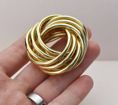 Gri arka planda altın broş. Mücevher aksesuarları.