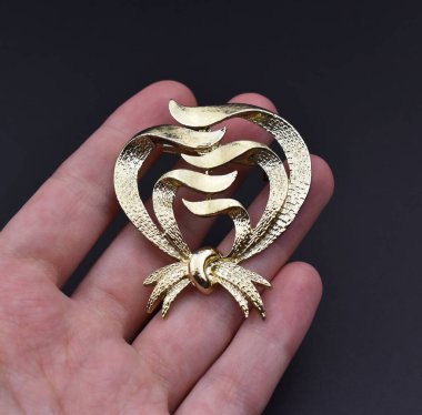 Karanlık bir arka planda altın bir kalbi tutan el. Yakın plan..