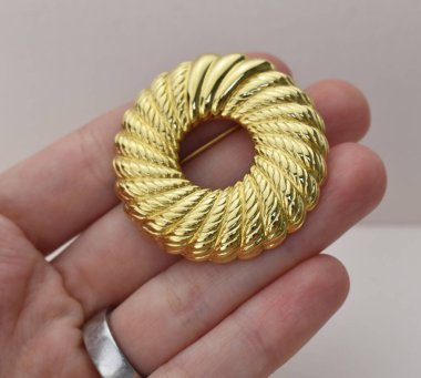 Gri arka planda altın broş, yakın plan.