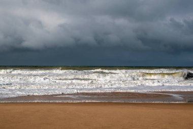 Fırtınalı deniz manzarası, kumsalda fırtına bulutları ve dalgalar