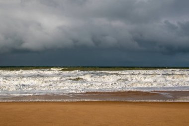 Fırtınalı deniz manzarası, kumsalda fırtına bulutları ve dalgalar