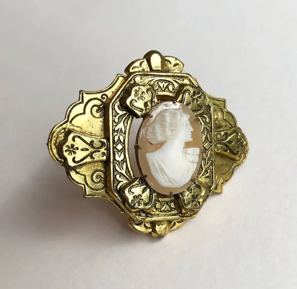 Bej arka planda eski bir broş, kadınlar için aksanlı eski takılar