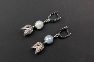 Siyah arka planda mavi değerli küpeler, yakın plan.