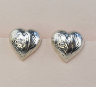 Beyaz arka planda iki gümüş kalp. Yakın plan. Sevgililer Günü.