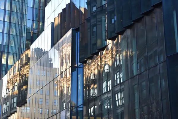Reflection of buildings in windows of modern office building. Business concept.