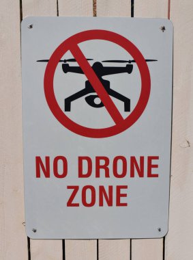 Arkasında insansız hava aracı olan ahşap bir duvarda İHA işareti yok.