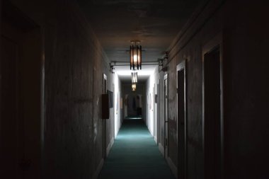 Karanlık bir odada, içinden ışık geçen uzun bir koridor..