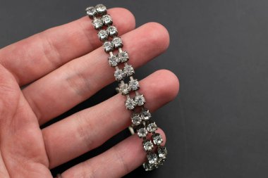 Siyah arka planda bir parmak üzerinde mücevher bileziği