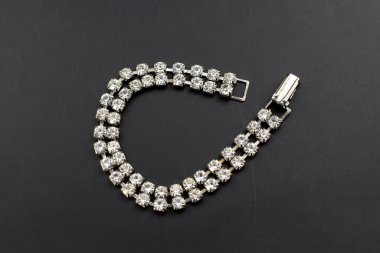 Siyah arkaplanda elmaslar olan gümüş bilezik. Moda mücevherleri..