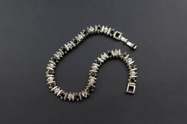 Bracelet made of silver beads on a black background close-up
