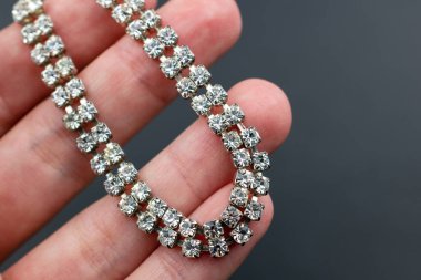 Koyu arkaplanda elmas bilezik var.