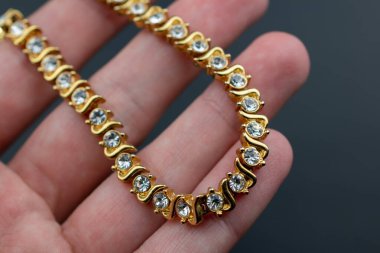 Koyu arkaplanda elmaslar olan güzel altın bilezik.