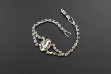 Siyah arkaplanda bilezik, yakın plan çekimde sığ bir alan derinliğinde.