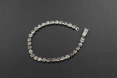 Siyah arkaplanda elmaslar olan gümüş bilezik. Moda mücevherleri..