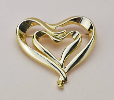 Beyaz arkaplanda kalp şeklinde bir kolye, yakın plan.