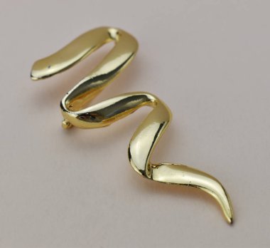 Beyaz arka plandaki altın broşu kapat. Makro.