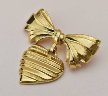 Beyaz arka planda altın broş, yakın plan.