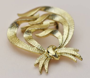 Hafif arka planda altın bir broş. yakın plan.