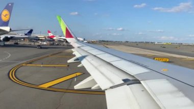 TAP Air Portugal uçağı pist boyunca seyahat ediyor ve uçak penceresinden kanada, Lizbon, Portekiz 'e kalkışa hazırlanıyor.