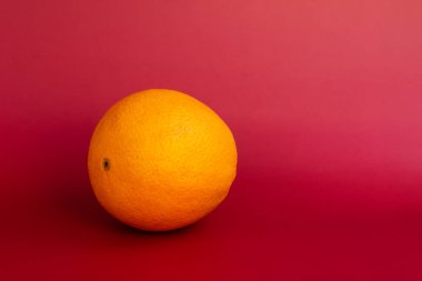 Kırmızı arka planda portakal meyvesi. Kırmızı arkaplanda turuncu.