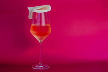 Fotokopi alanı olan pembe bir arka planda şarap kadehinde kokteyl.