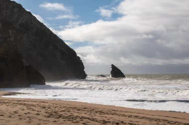 Portekiz 'in kuzeyinde kumsal. Arkasında kayalar var..