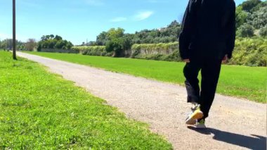 Güneşli bir günde doğada yürüyen beyaz bir kadın.