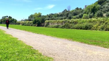 Güneşli bir günde doğada yürüyen beyaz bir kadın.
