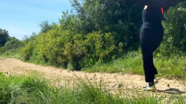 Güneşli bir günde doğada yürüyen beyaz bir kadın.