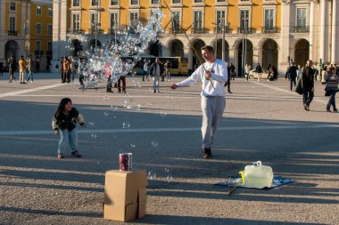 Lizbon meydanında sabun köpüğüyle oynayan bilinmeyen bir adam..
