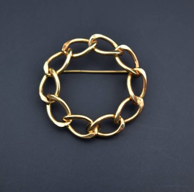 Siyah arka planda altın broş. Mücevherler. Moda mücevherleri..