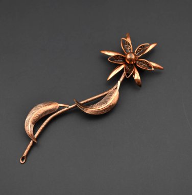 Siyah arkaplanda kopyalama alanı ile izole edilmiş klasik bakır çiçek klibi.