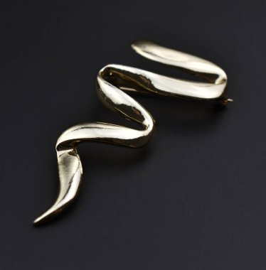 Koyu arkaplanda altın bir broş..