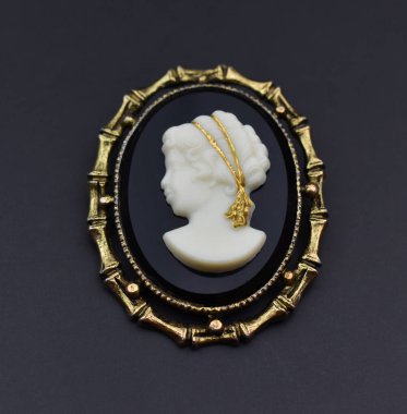 Siyah bir arkaplanda eski bir çerçevede bir kadın heykelciği kapat