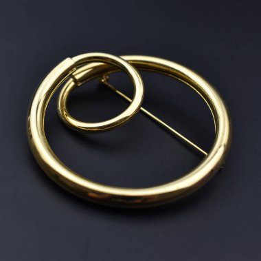 Fotokopi alanı olan siyah bir arkaplanda altın bir broşu kapat