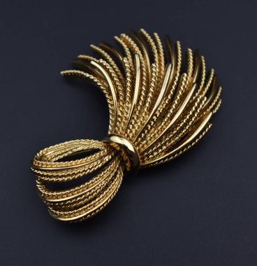 Koyu arkaplanda altın broş. Yakın plan fotoğraf..