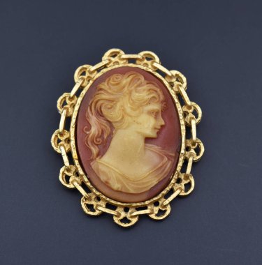 Altın çerçeveli bir kolyeye yakın dur.