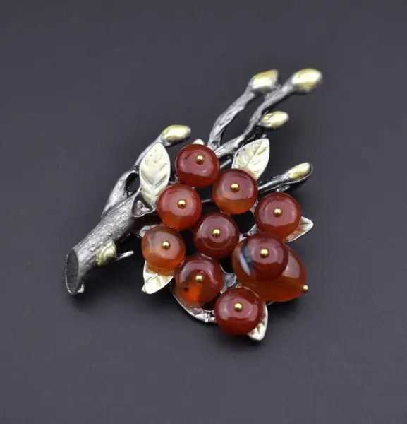 stock image Handmade brooch with red beads on a black background close-up