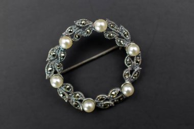 Siyah arka planda incili gümüş broş, üst manzara..