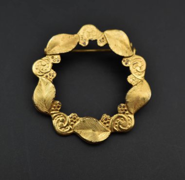 Siyah arka planda lüks altın bir broş..