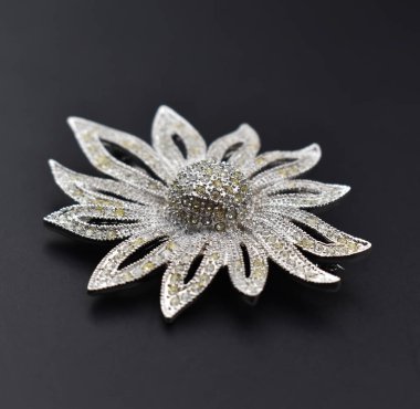 Siyah arkaplanda gümüş broş, yakın plan, dikey