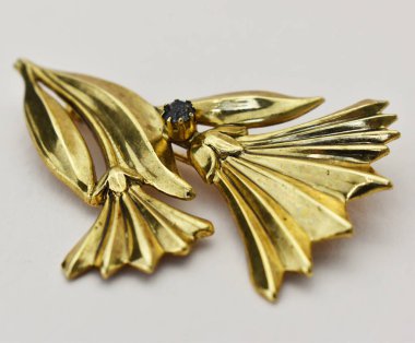 Beyaz arka planda altın çiçekli broş. Stüdyo çekimi.