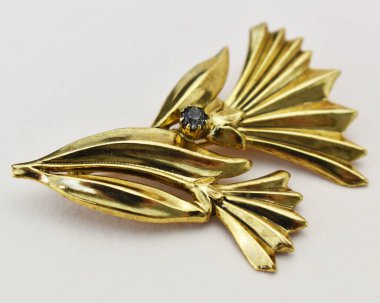 Beyaz arkaplanda altın broş, yakın plan, seçici odak