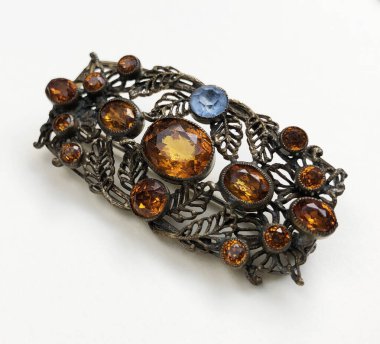 Beyaz arka planda kehribar broşu, yakın plan.