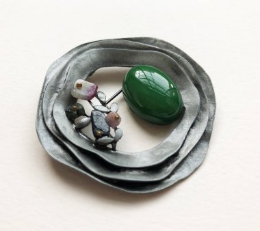 Beyaz arka planda değerli taşlı mücevher broşu, yakın plan.